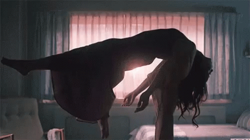 A Silhouette Of A Woman Floating In The Air With A Window Behind Her GIF