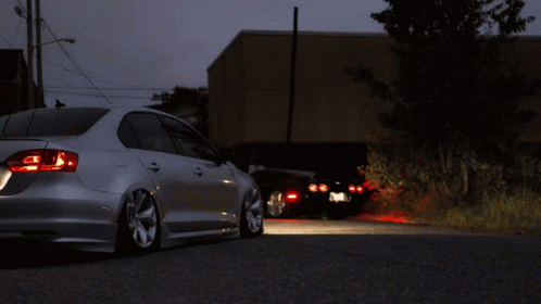 A Silver Car Is Parked On The Side Of A Road GIF