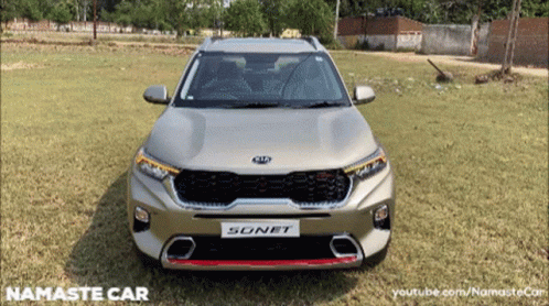 A Silver Kia Sonet Is Parked In The Grass GIF
