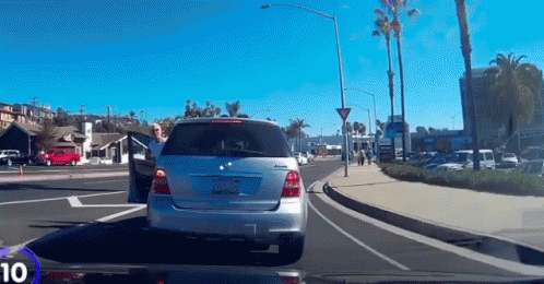A Silver Mercedes With A California License Plate Is Driving Down The Street GIF