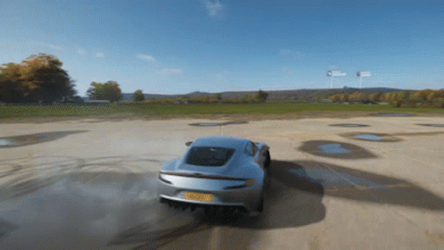 A Silver Sports Car With A License Plate That Says ' Rsc ' On It Is Driving Down A Dirt Road GIF