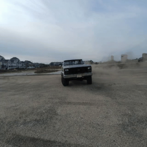 A Silver Truck With A New Jersey License Plate Is Driving Through A Dirt Field GIF