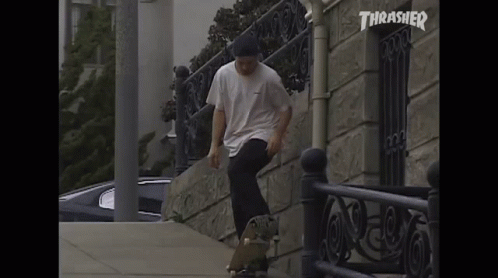 A Skateboarder Is Doing A Trick In Front Of A Building With Thrasher Written On It GIF
