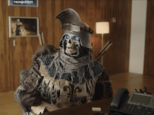 A Skeleton In Armor Is Sitting At A Desk With A Telephone GIF