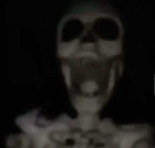 A Skeleton Is Hanging From The Ceiling With A Knife Sticking Out Of Its Head . GIF