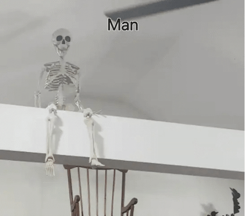A Skeleton Is Sitting On A Wall Next To A Wooden Chair . GIF