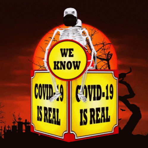 A Skeleton Wearing A Mask Sits On Top Of A Sign That Says We Know Covid-19 Is Real GIF