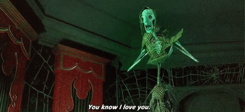 A Skeleton With A Green Mask Is Saying `` You Know I Love You '' In A Dark Room . GIF