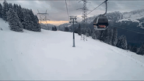 A Ski Lift Is Going Up A Snow Covered Slope GIF