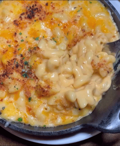 A Skillet Of Macaroni And Cheese With A Spoon GIF