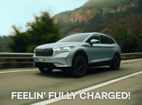 A Skoda Car Is Driving Down A Road With The Words Feelin ' Fully Charged Behind It GIF