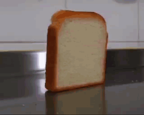 A Slice Of Bread Is Sitting On A Counter Top . GIF