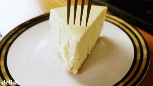 A Slice Of Cheesecake On A Plate With The Word Delish On The Bottom Right GIF