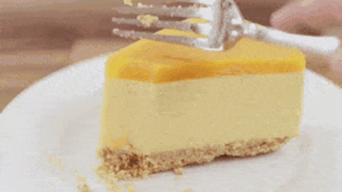 A Slice Of Cheesecake On A White Plate With A Knife . GIF