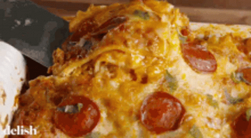 A Slice Of Pepperoni Pizza Is Being Taken Out Of A Casserole Dish GIF