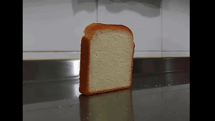 A Slice Of White Bread Is Sitting On A Counter GIF