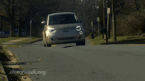 A Small Car Is Driving Down A Street With Motorweek.org Written On The Bottom GIF