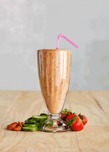A Smoothie With Strawberries And Cucumbers On The Table GIF