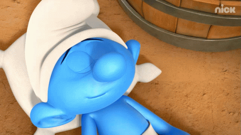 A Smurf Is Laying On The Ground With His Eyes Closed Next To A Barrel That Says Nick On It GIF