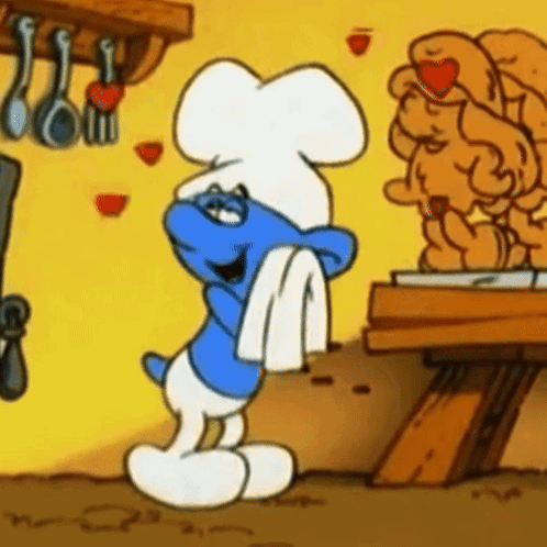 A Smurf Wearing A Chef 'S Hat Is Standing In Front Of A Statue GIF