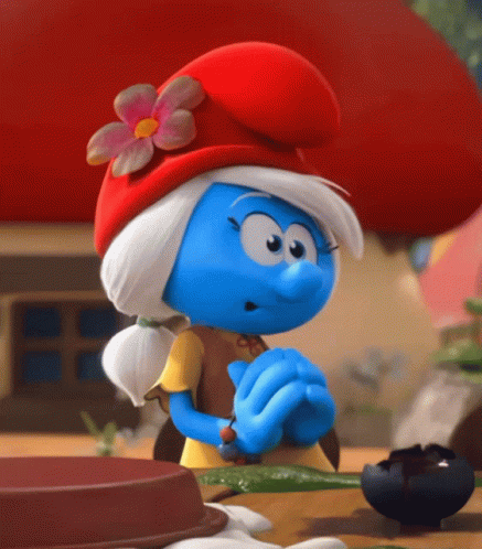 A Smurf Wearing A Red Hat And A Yellow Shirt GIF