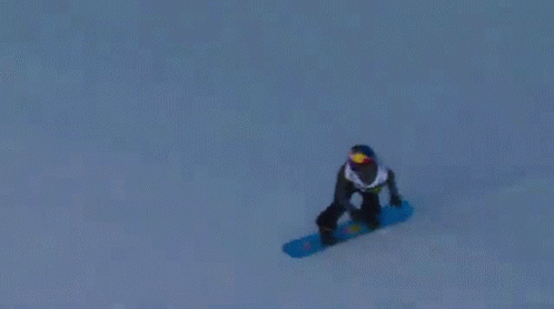 A Snowboarder Is Doing A Trick On A Snowy Slope GIF