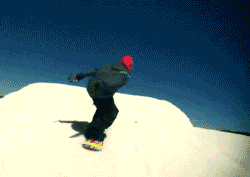 A Snowboarder Is Doing A Trick On Top Of A Snow Covered Hill GIF