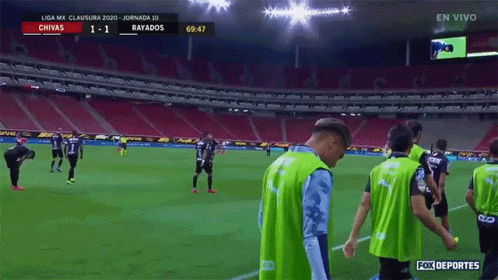 a soccer game between chivas and rayados is being played in a stadium