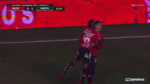 A Soccer Game Is Being Played Between Xolos And Santos And The Players Are Hugging GIF