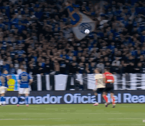 A Soccer Game Is Being Played In Front Of A Banner That Says " Cronador Oficial Del Real " GIF