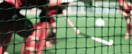 A Soccer Game Is Being Played On A Field Behind A Fence GIF