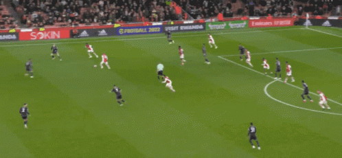 a soccer game is being played on a field that has an emirates banner on the side