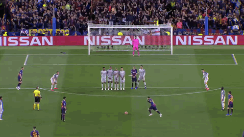 A Soccer Game Is Being Played On A Field With A Nissan Banner Behind The Goal GIF