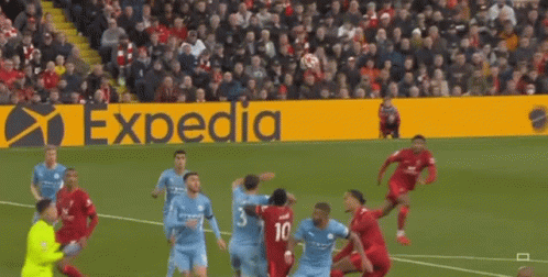 A Soccer Game Is Being Played On A Field With An Expedia Sign In The Background GIF