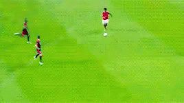 a soccer game is being played on a field with players in red and black uniforms
