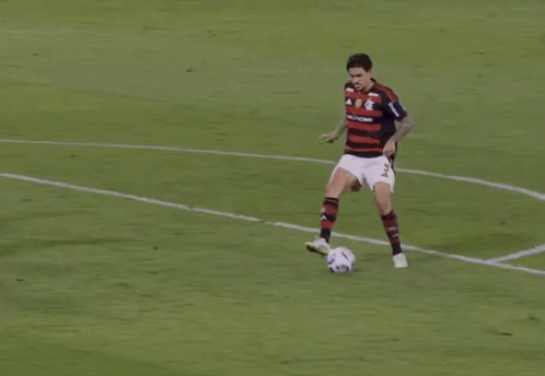 a soccer goalie catches a soccer ball in a net with the letter b on it