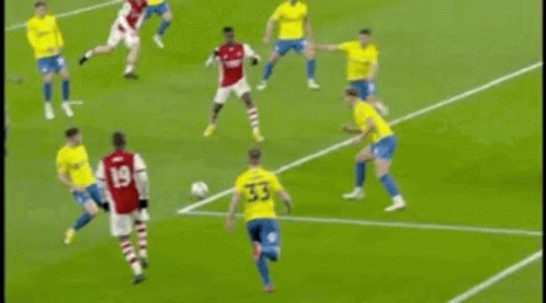 A Soccer Goalie Is Diving To Catch A Soccer Ball On A Field . GIF