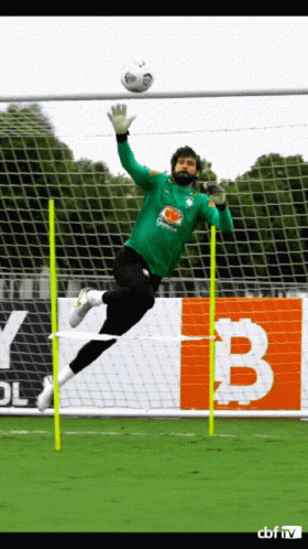 A Soccer Goalie Jumps In The Air To Catch The Ball GIF