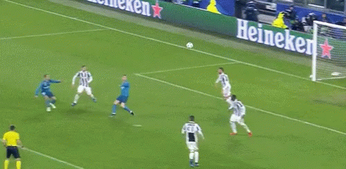 A Soccer Goalie Jumps To Catch A Ball In Front Of A Sign That Says 7 GIF
