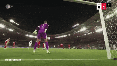 a soccer goalie with the number 1 on his jersey jumps to catch a ball