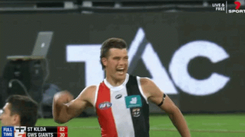 A Soccer Player Celebrates A Goal In Front Of An Ad For Tac GIF