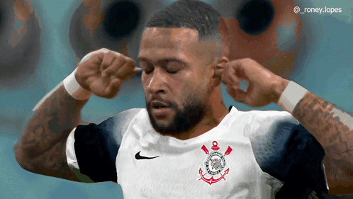a soccer player covering his ears with his hands