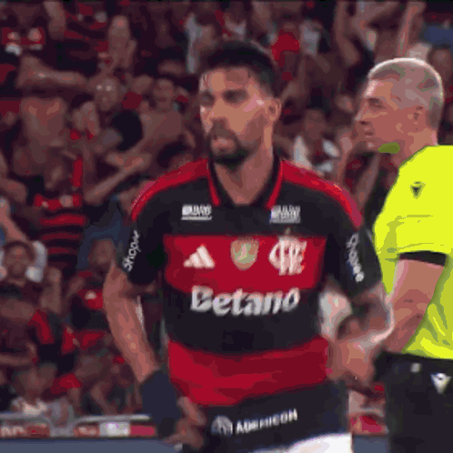 a soccer player giving a thumbs up in front of a scoreboard that has the number 2 on it