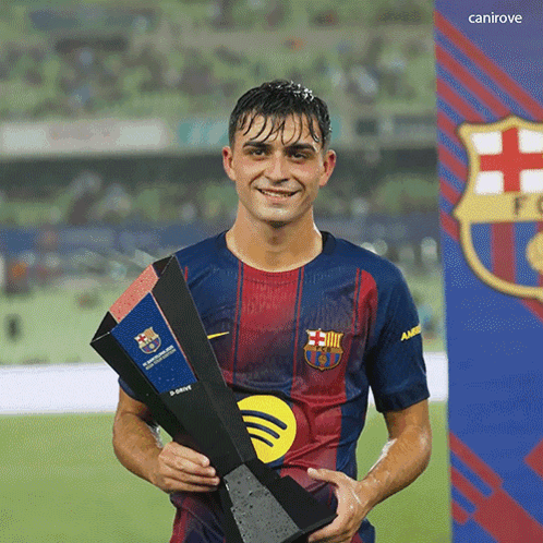 a soccer player holding a trophy in front of a canirove sign