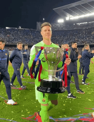 A Soccer Player Holding A Trophy With A Pepsi Logo On His Jersey GIF