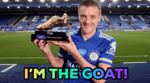 a soccer player holding a trophy with the words i 'm the goat below him