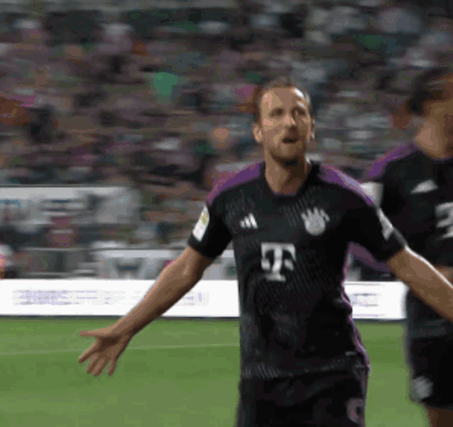 A Soccer Player In A Black And Purple Jersey With The Letter T On The Front GIF
