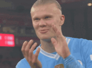 A Soccer Player In A Blue Jersey Is Clapping His Hands . GIF