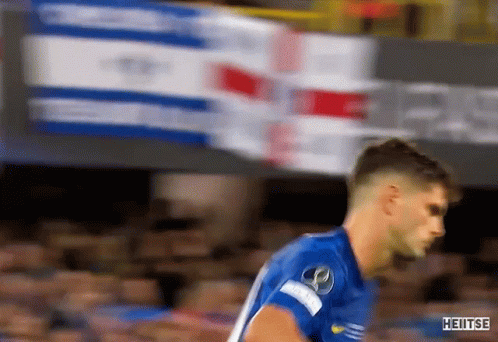 a soccer player in a blue shirt is running on a field .