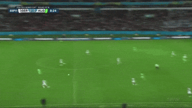 a soccer player in a green jersey kicks a soccer ball